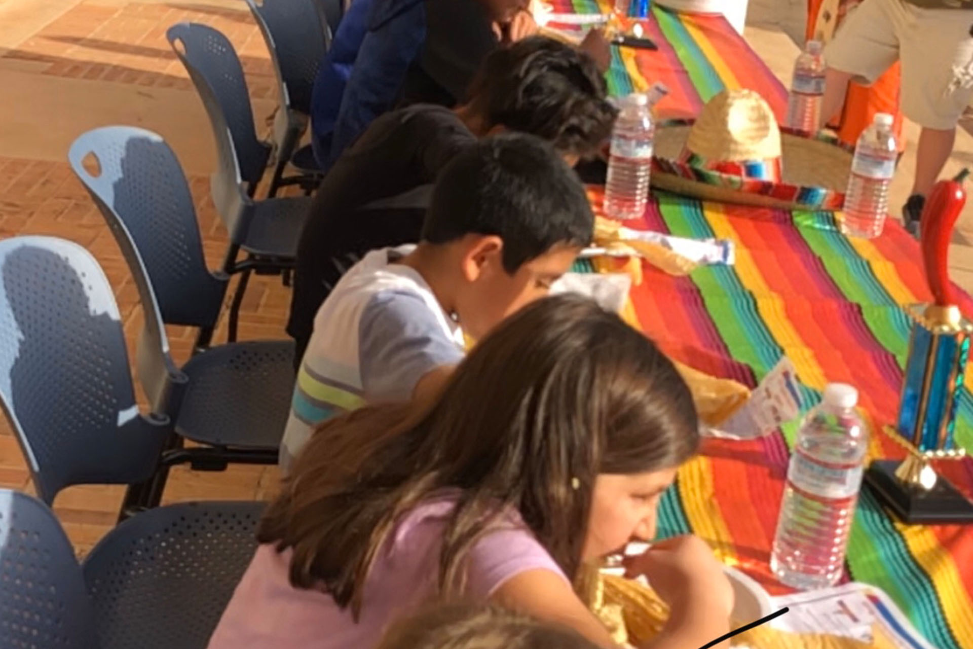 Image of kids eating tamales during a tamale eating contest.
