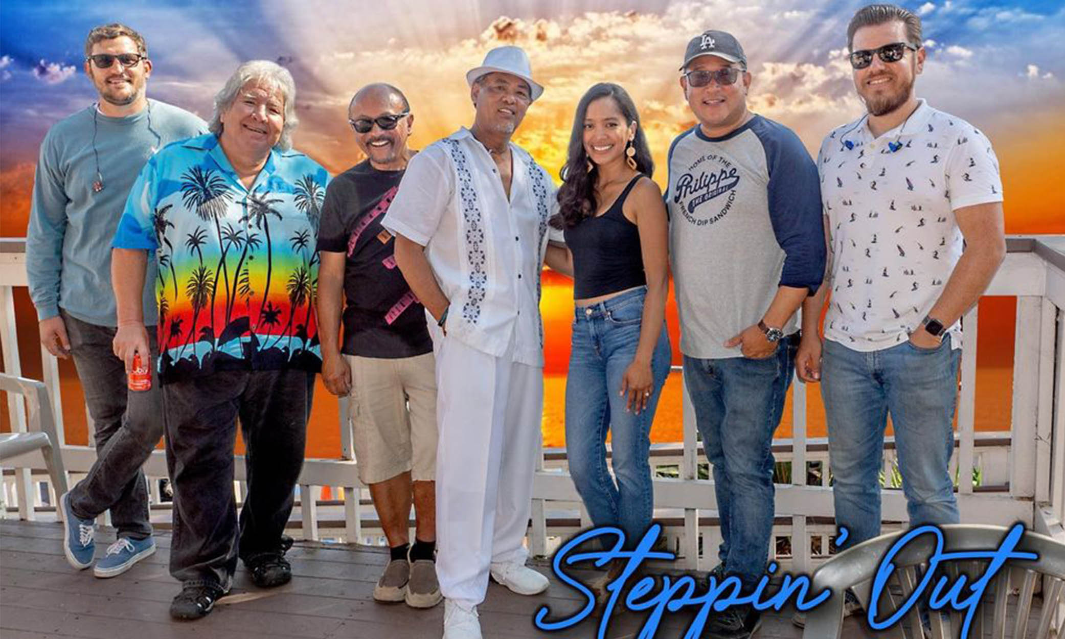 Image of the Steppin Out Band standing in front of a beach sunset.